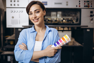 Woman working in printing house holding swatch palette