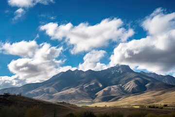 Wall Mural - majestic mountain range in the daytime, with blue skies and puffy clouds, created with generative ai