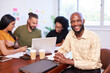 © Meeko Media - Portrait of smiling Black man, development team, mobile app coding meeting