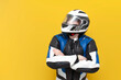 © Богдан Маліцький - young guy motorcyclist in leather jacket and helmet stands with his arms crossed on yellow isolated background