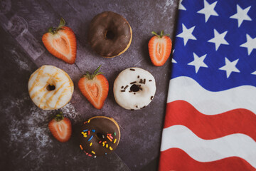 Donuts. Top view. Colorful donuts with icing. On the black background . Colorful glazed doughnuts with sprinkles. Independence Day 4th of July