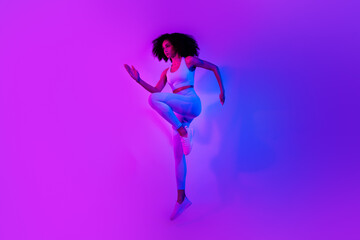 Poster - Full body photo of sporty fitness blogger jumping intense dynamic workout isolated on ultraviolet color neon background