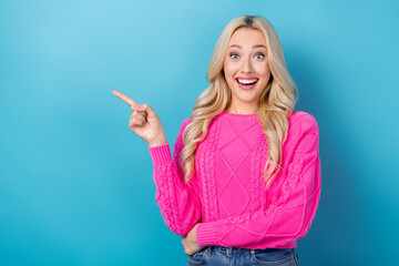 Sticker - Photo of adorable excited woman dressed knitted pullover showing finger empty space isolated blue color background