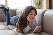 Unhappy Preteen Girl Using Smartphone Reading Depressing News At Home