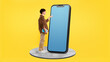 © Prostock-studio - Student Man Touching Huge Phone Empty Screen On Yellow Background
