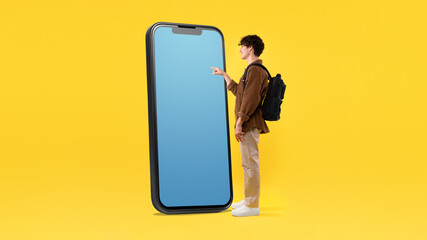 Guy With Backpack Using Giant Phone With Empty Screen, Studio