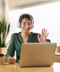 Virtual meeting, business woman and wave on a video call with headphones and greeting. Laptop, working and female employee with webinar at a company with computer and digital communication at office