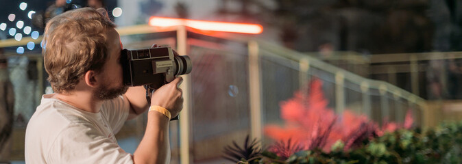 Wall Mural - Director of photography with a camera in his hands on the set. Professional videographer at work on filming a movie