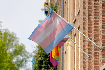 Celebration of pride month in Amsterdam, Transgender flag (Blue, Pink, White) hanging outside building, This symbolizes us trying to find correctness in our own lives, LGBTQ community in Netherlands.