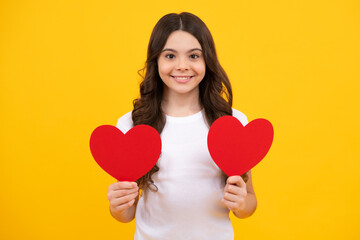 Poster - Lovely romantic teenage girl hold red heart symbol of love for valentines day isolated on yellow background. Happy teenager, positive and smiling emotions of teen girl.