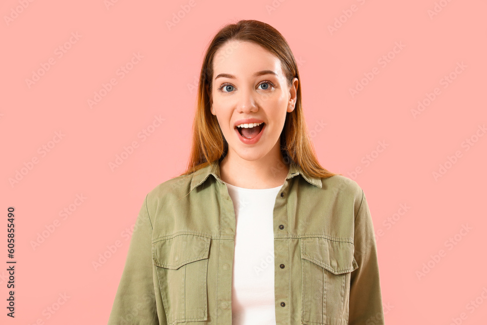 Surprised young woman on pink background