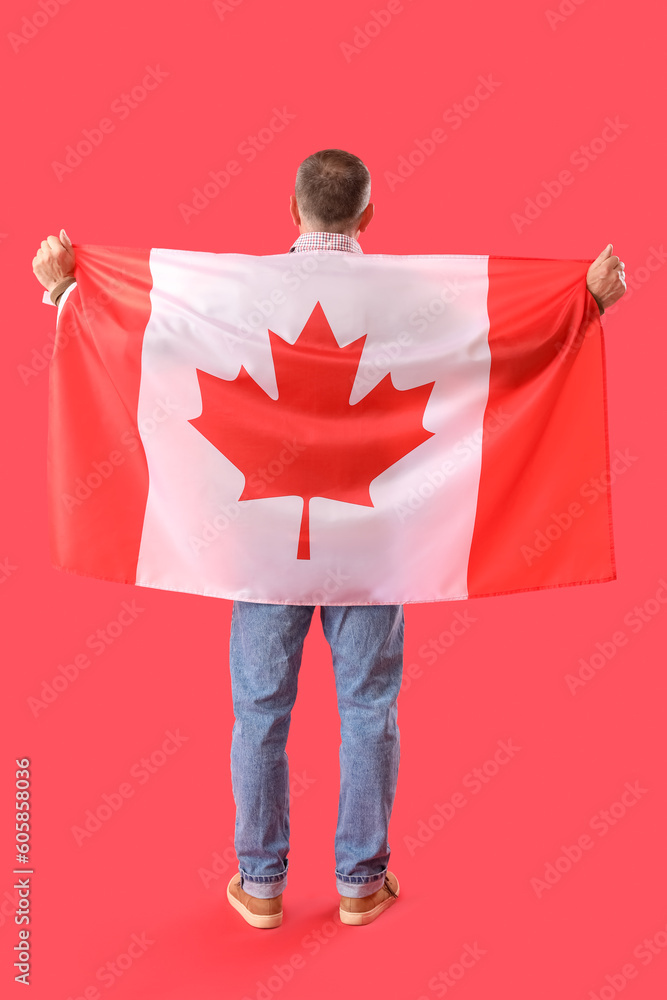 Mature man with flag of Canada on red background, back view