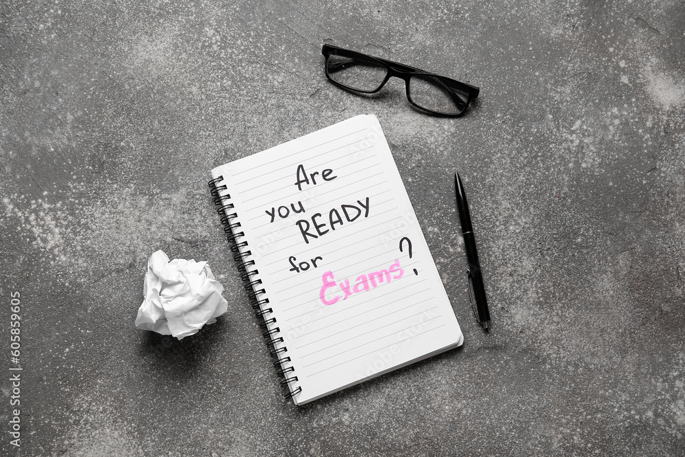 Notebook with question ARE YOU READY FOR EXAMS?, eyeglasses and pen on grunge grey background