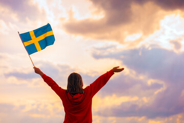 Woman Swedish Flag Looking at the Sky.  Optimistic girl holding national flag celebrating Scandinavian culture 

