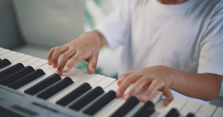 Wall Mural - Cute boy enjoy to learning playing piano at home