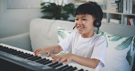 Wall Mural - Cute boy enjoy to learning playing piano at home