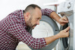 © auremar - a plumber repairing washing machine