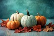 Selection of pumpkins in different tones with fall leaves