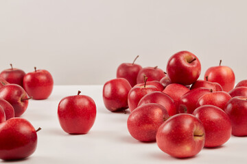 Wall Mural - Front view of ripe red apples are decorated on a white background. Apples have many uses in beauty such as: whitening, exfoliating, tightening pores and anti-aging. Background for advertising