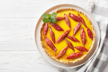 Wall Mural - Delicious rhubarb pie with custard closeup on the plate on the wooden table. Horizontal top view from above