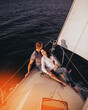 Beautiful couple looking in sunset from the yacht. Romantic vacation .