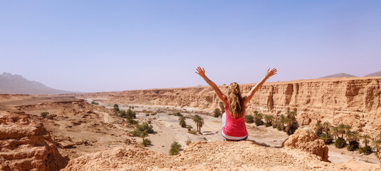 Wall Mural - Woman with arms raised, cliff and canyon- Morocco