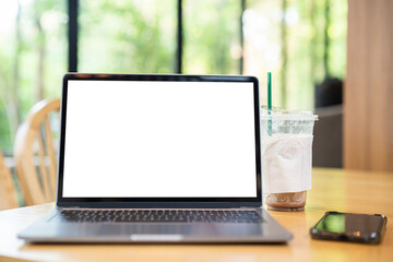 Mockup of laptop computer with empty screen with coffee cup and smartphone on table of the coffee shop background,White screen