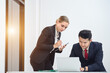 © เลิศลักษณ์ ทิพชัย - Asian manager with caucasian female secretary working on laptop Examine contract documents and professional investment contracts at the meeting room.