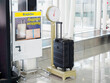 空港の荷物用はかりでスーツケースの重さを測っている様子