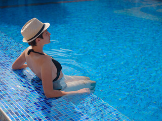 Wall Mural - asian woman relaxing in swimming pool spa