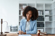 © Jirapong - Young African American lawyer studying a case for a client and signing a legal contract to fight her opponent in court. Legal and lawyer concepts.