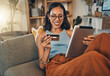 Ecommerce, credit card and woman on a couch, tablet or payment with an order, home or online shopping. Female person, girl or customer on a sofa, technology or buying products with retail or banking