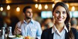 © Pictures Paradise - Portrait of smiling waitress in restaurant looking at camera with bokeh background.