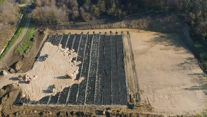 Canvas Print - Aerial video of tractor drivers working in a pit for the construction of a new building