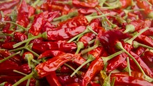 Close-up shot of scattering red hot chili peppers on a wooden table