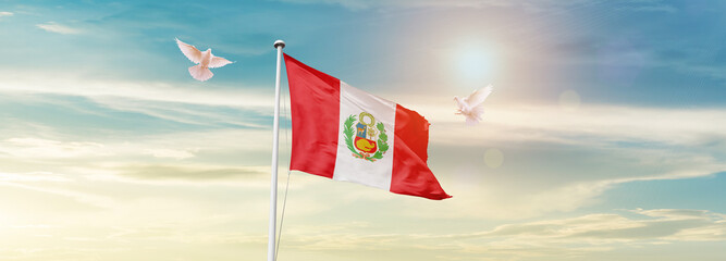 Wall Mural - Waving Flag of Peru in Blue Sky. The symbol of the state on wavy cotton fabric.