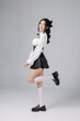 Full length Pretty teenage Asian High School woman model in student uniform has lovely face is with perfect clear fresh skin on grey isolated background. Facial treatment, Cosmetology, body care.