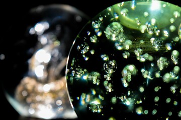 Closeup of two snow globes with a black background