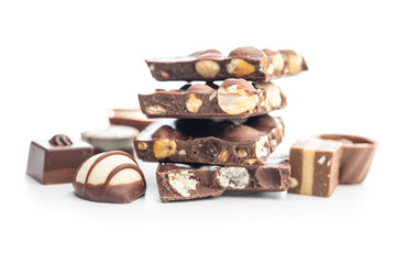 Poster - Broken chocolate bars with  nuts and pralines isolated on white background.