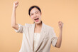 © Jirawatfoto - Studio portrait of happy successful confident young asian business woman. Beautiful young lady in white jacket smiling at camera standing isolated on solid beige colour copyspace background