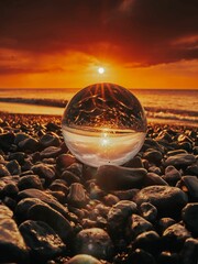 Wall Mural - Close up of a crystal ball on a beach during sunset