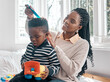 Black family, mother and comb hair of kid in home bedroom for grooming, care or bonding. African mom, smile and combing child or boy for afro hairstyle, haircare and playing to enjoy time together.