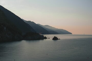 Poster - Landscape of sunset ocean mountains with a hazy sky