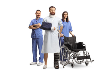 Patient in a hospital gown with a broken leg and arm standing with a team of medical workers