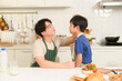 © tonefotografia - Happy Young Asian father giving support to his son  in kitchen at home
