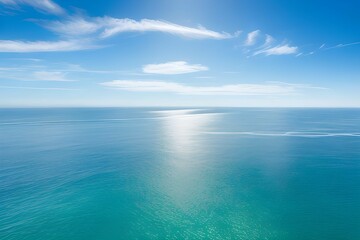 海の水面に日光が輝く、空は美しい雲と青空