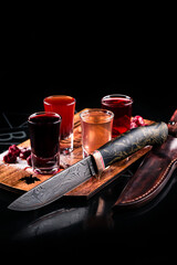 A beautiful sharp knife on the background of alcoholic tinctures.