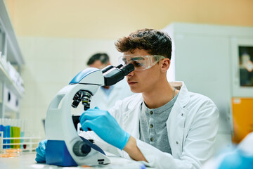 Wall Mural - laboratory scientist using microscope while working on medical research.