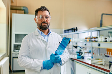 Wall Mural - male biochemist working in laboratory and looking at camera.