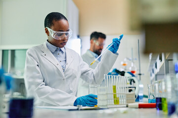 Wall Mural - black female biochemist working on scientific research in laboratory.